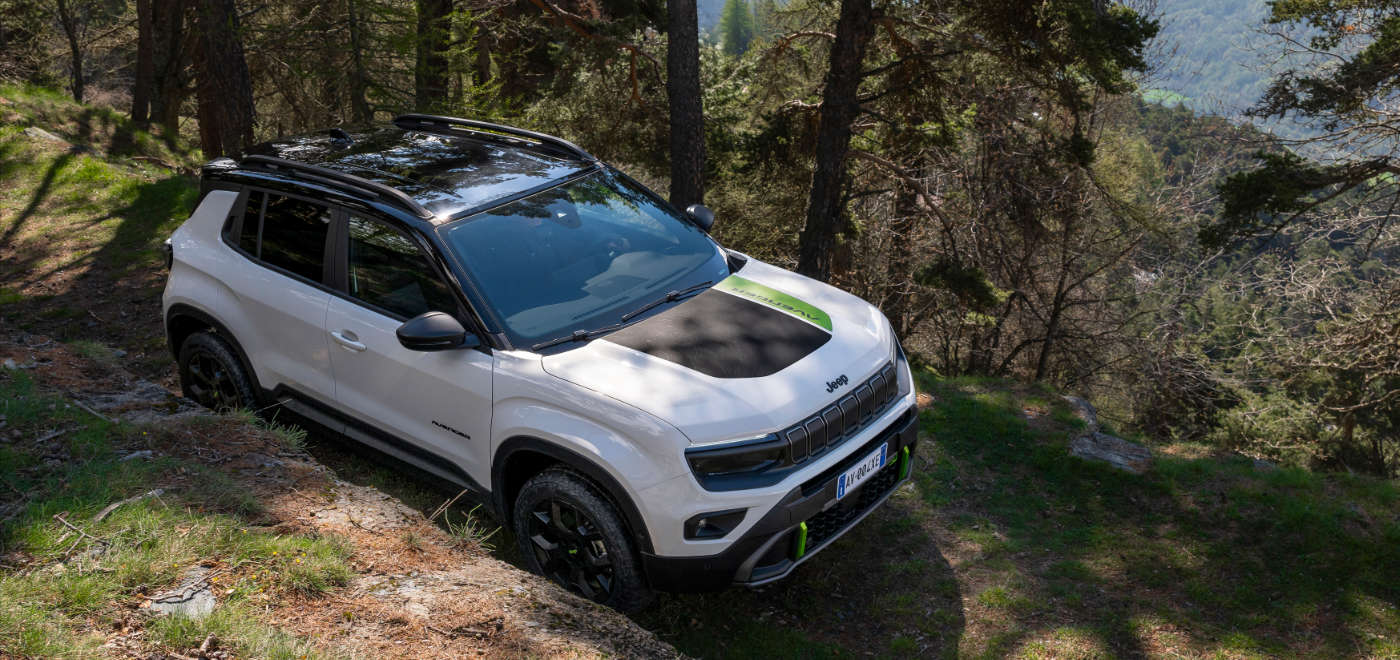 Jeep Avenger 4xe білого кольору, вигляд зверху спереду з правого боку у горах