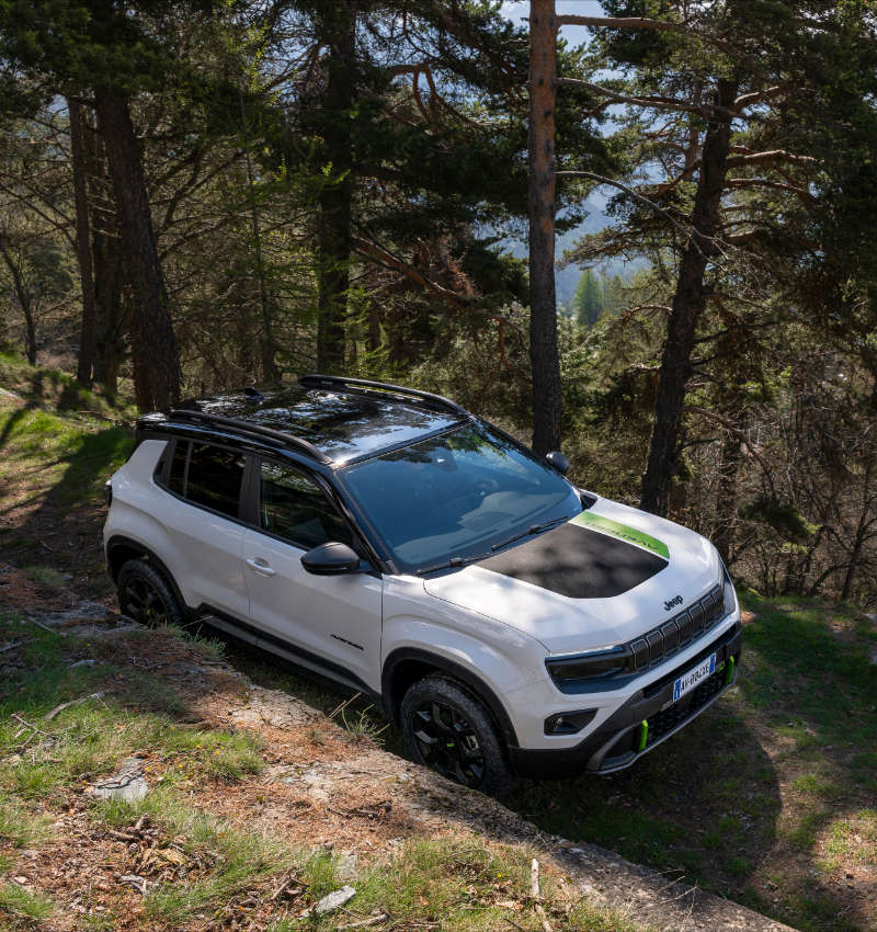 Jeep Avenger 4xe білого кольору, вигляд зверху спереду з правого боку у горах