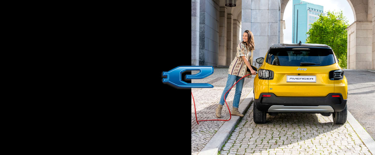 Електромобіль Jeep Avenger, дівчина встромляє штекер у зарядне гніздо